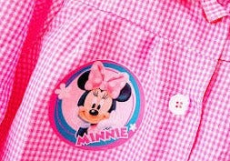 Bata escolar de cuadritos de color rosa con botones con tus personajes favoritos
